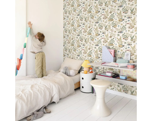 Lichte kinderkamer met bed, nachtkastje, plank, kruk en een muur met behang met dierenmotief.