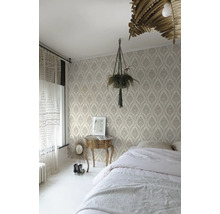 Slaapkamer met patroonbehang, bed, nachtkastje en kamerplant