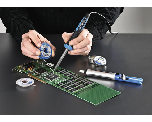 Persoon soldeert een printplaat met een soldeerbout, soldeertin en desoldeerpomp.