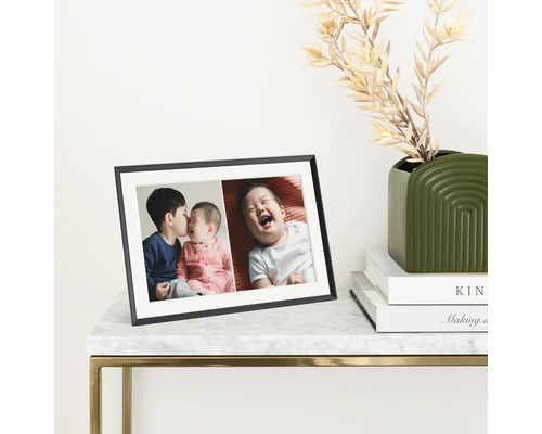 Zwarte fotolijst met foto's op een tafel
