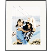 Zwarte fotolijst met witte passe-partout en een foto van een vrouw met kind voor de Golden Gate Bridge.