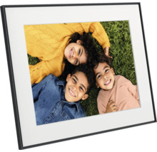 Zwarte fotolijst met een witte passe-partout en een foto van drie lachende kinderen op een grasveld.