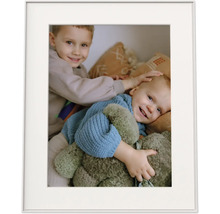 Fotolijst met passe-partout en een foto van twee glimlachende kinderen met een knuffel.