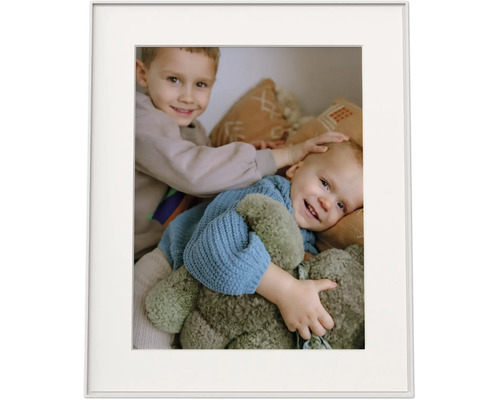 Fotolijst met passe-partout en een foto van twee glimlachende kinderen met een knuffel.