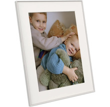 Witte fotolijst met passe-partout, schuin afgebeeld, met een foto van twee lachende kinderen met een teddybeer.