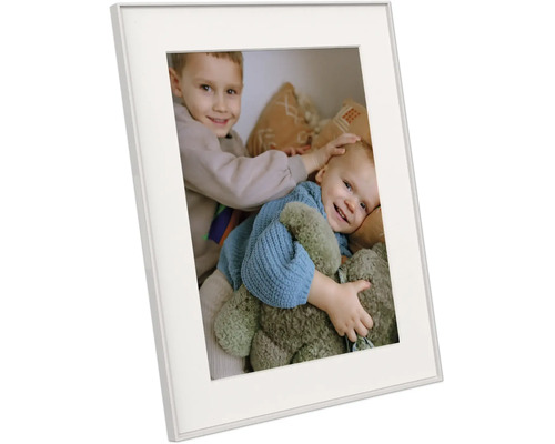 Witte fotolijst met passe-partout, schuin afgebeeld, met een foto van twee lachende kinderen met een teddybeer.