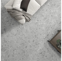 Kameroverzicht met vloertegels in steenlook, bank en tafel.