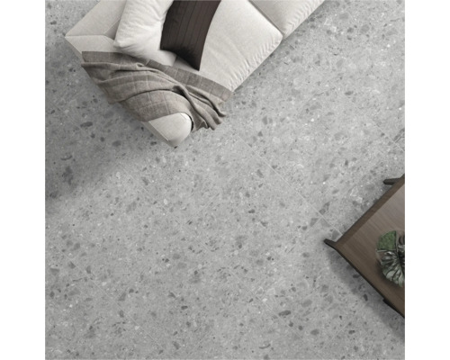 Vloertegels in woonkamerscène met bank en tafel.