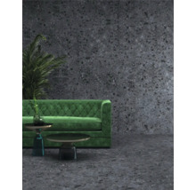 Scene met groene bank, twee tafels en een plant tegen een donkere muur met stippenpatroon.