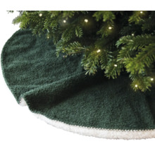Groene kerstboomkleed met witte rand onder een kerstboom