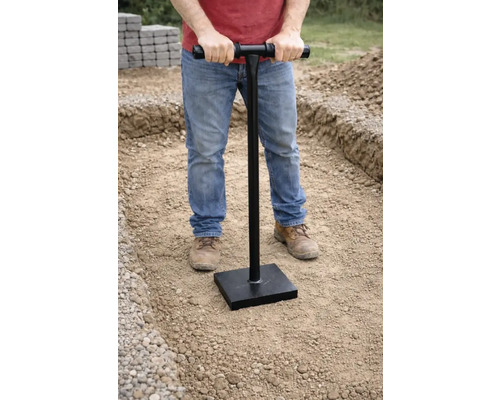 Man verdicht grond met een handstamper