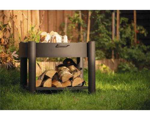 Metalen brandhoutrek met brandhout in de tuin