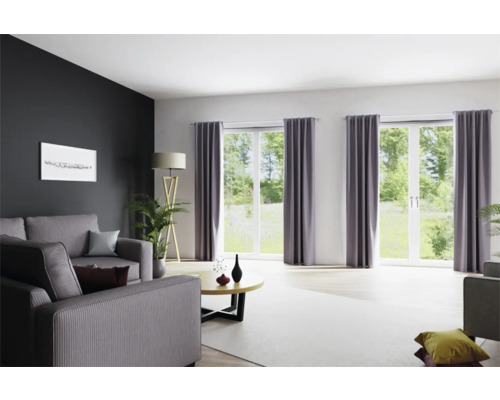 Woonkamer met bank, ramen met gordijnen en staande lamp