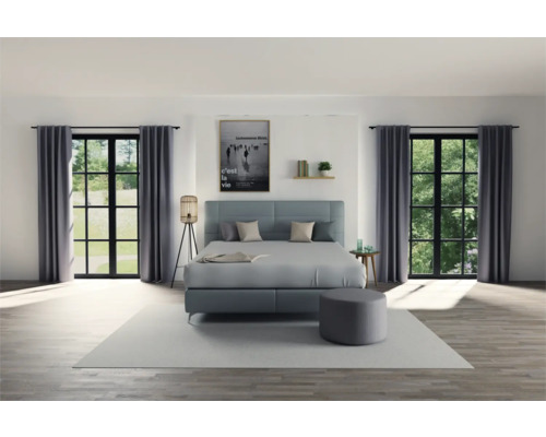 Slaapkamer met boxspringbed, gordijnen en decoratie