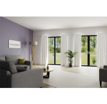 Lichte woonkamer met bank, vloerlamp en grote ramen met gordijnen