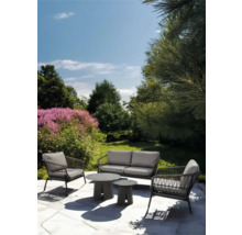 Tuinmeubelset met bank, fauteuils en tafels in de tuin