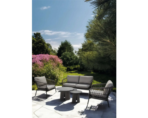 Tuinmeubelset met bank, fauteuils en tafels in de tuin