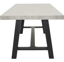 Eettafel met betonnen tafelblad en zwart metalen onderstel.