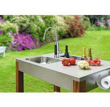 Buitenkeuken met spoelbak, kraan, groenten, champagne en papierhanddoekhouder in de tuin