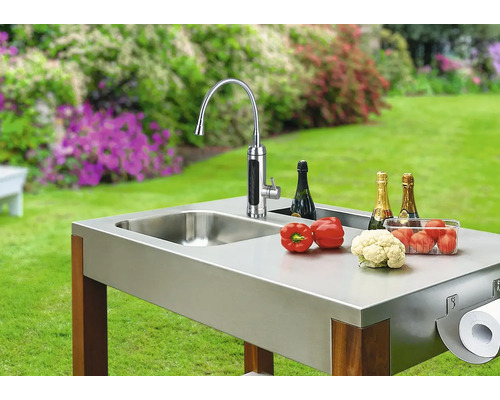 Buitenkeuken met spoelbak, kraan, groenten, champagne en papierhanddoekhouder in de tuin
