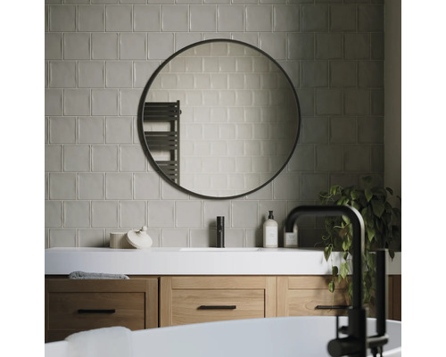 Moderne badkamer met wastafel, ronde spiegel en tegels