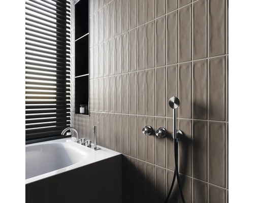 Moderne badkamer met ligbad, kranen, planken en langwerpige wandtegels