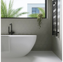 Badkamer met bad, handdoekradiator en zeshoekige wandtegels