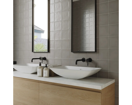 Moderne badkamer met dubbele wastafel, kranen, spiegels en grijze wandtegels