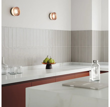 Keukenscène met wandlampen, tegels en keukengerei op het aanrecht.