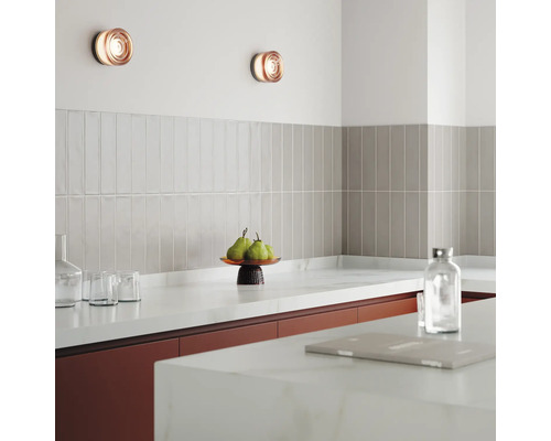 Keukenscène met wandlampen, tegels en keukengerei op het aanrecht.