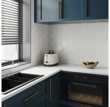 Moderne keuken met spoelbak, broodrooster, oven en zeshoekige wandtegels.