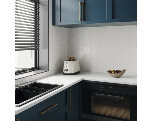 Moderne keuken met spoelbak, broodrooster, oven en zeshoekige wandtegels.