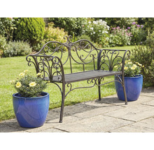 Versierde metalen tuinbank met bloempotten op een tuinterras