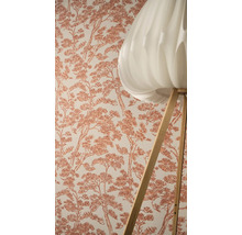 Vliesbehang met grafisch boompatroon naast een vloerlamp met lichte lampenkap en houten onderstel.