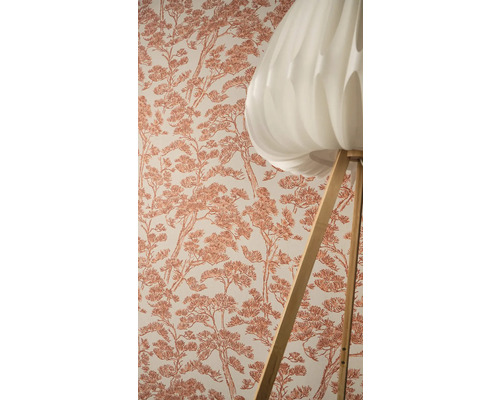 Vliesbehang met grafisch boompatroon naast een vloerlamp met lichte lampenkap en houten onderstel.