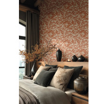 Elegant ingerichte slaapkamer met behang met boompatroon, houten hoofdbord, decoratieve kussens met botanische motieven en donkere keramieken vazen.