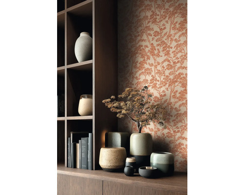 Vliesbehang met dennenpatroon in roestlook achter een donkerhouten kast met keramieken vazen en boeken.