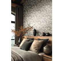 Moderne slaapkamer met vliesbehang met bosontwerp, houten bed met grijze en beige kussens en decoratieve vazen.