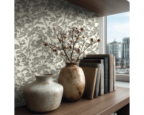 Vliesbehang met boompatroon in schetsstijl op een muur achter een houten plank met keramieken vazen en boeken in een lichte kamer.