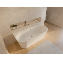 Vrijstaand bad in een lichte badkamer met opbergplanken