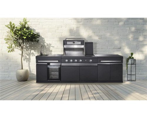 Moderne buitenkeuken met barbecue, spoelbak en koelkast voor een witte bakstenen muur