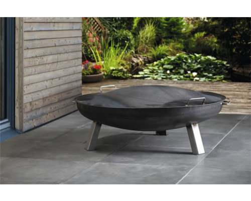 Metalen vuurschaal met afdekking in de tuin