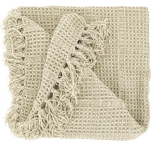 Beige woondeken met wafelstructuur en franjes.
