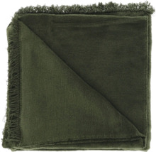 Groene woondeken met franjes, gevouwen.