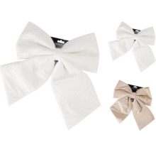 Decoratieve kerststrikken met ribstructuur in wit en beige.