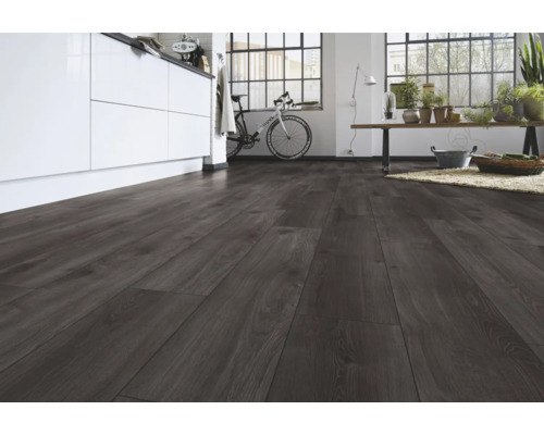 Donkere laminaatvloer met houtlook in een moderne, lichte ruimte met kookeiland en groot raam.