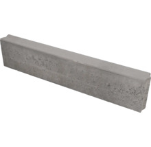 Grijze opsluitband van beton met een gestructureerd oppervlak en vellingkant.