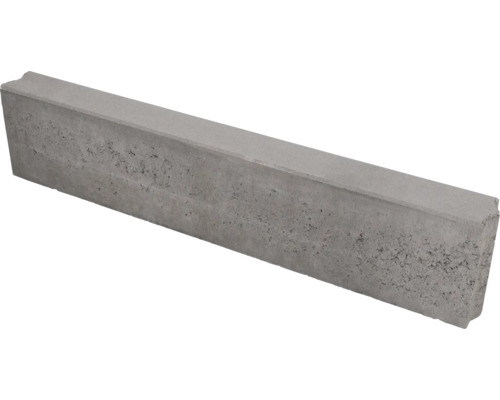 Grijze opsluitband van beton met een gestructureerd oppervlak en vellingkant.