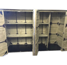 Interieur van een houten berging met open deuren, diverse legplanken en een zwarte vloer.