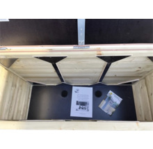 Binnenaanzicht van een houten opbergbox voor de tuin met zwarte bodem, ventilatiegaten en handleidingen.